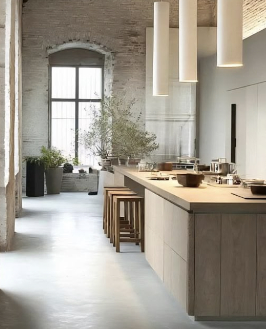 Lange houten keuken in een hoge ruimte met baksteen